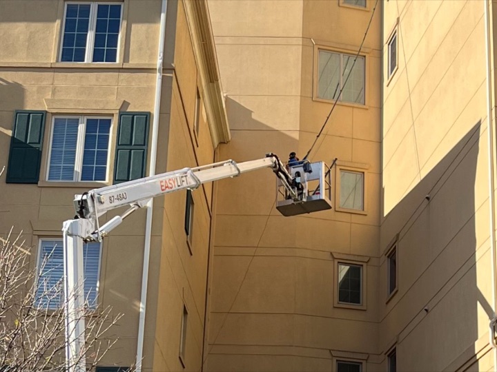 Sapphire technicians washing a building from a lift