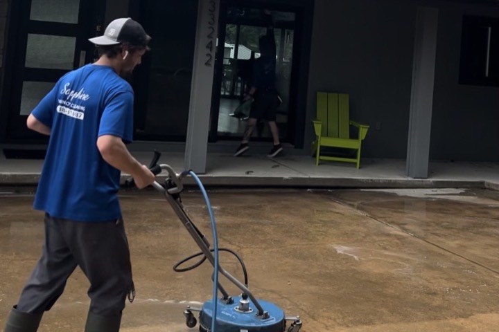 A Sapphire technician pressure washing a patio with a surface cleaner